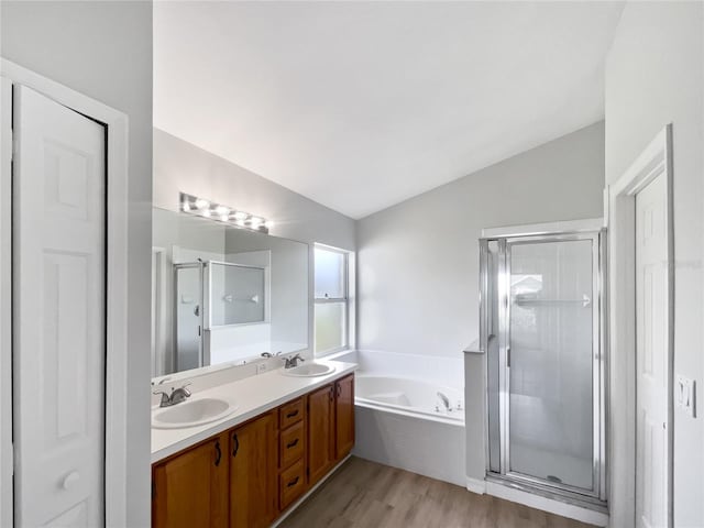 full bath featuring lofted ceiling, a stall shower, a sink, and a bath