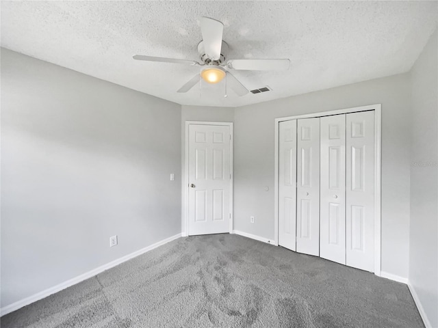 unfurnished bedroom with baseboards, a textured ceiling, visible vents, and carpet flooring