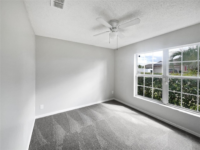 unfurnished room with a textured ceiling, carpet floors, a ceiling fan, and baseboards