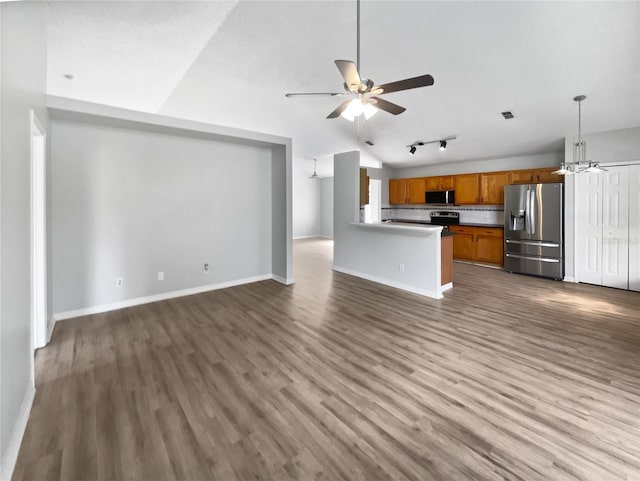 unfurnished living room with ceiling fan with notable chandelier, visible vents, baseboards, vaulted ceiling, and dark wood-style floors