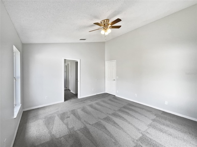 unfurnished bedroom with a textured ceiling, a ceiling fan, baseboards, vaulted ceiling, and dark carpet