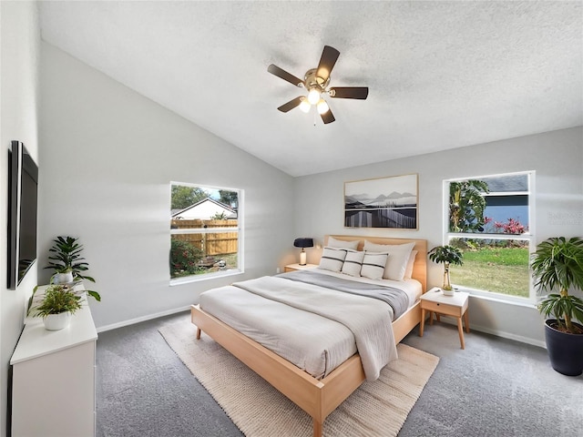 bedroom featuring carpet floors, lofted ceiling, ceiling fan, a textured ceiling, and baseboards