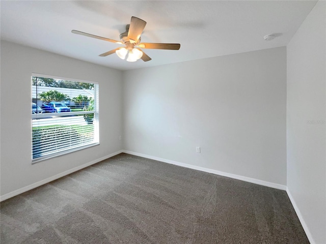 carpeted empty room with a ceiling fan and baseboards