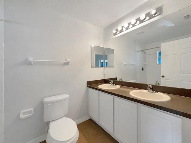 bathroom with baseboards, a sink, toilet, and walk in shower