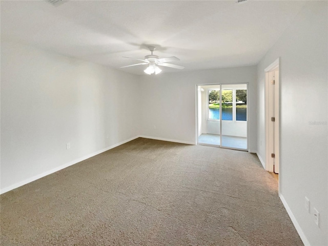 empty room featuring carpet, a ceiling fan, and baseboards