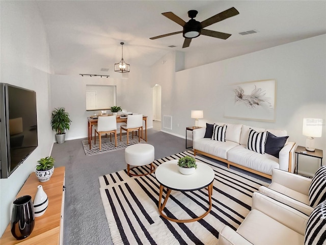 living room with ceiling fan with notable chandelier, visible vents, and baseboards