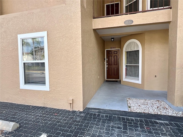 doorway to property featuring stucco siding