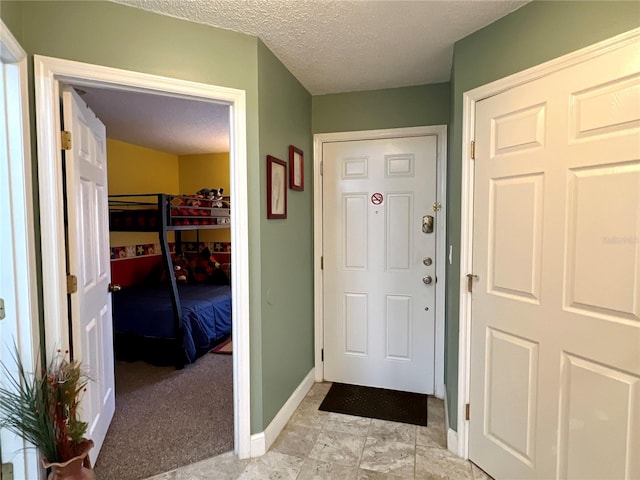 entryway featuring baseboards and a textured ceiling