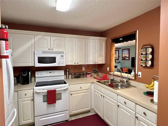 kitchen featuring a textured ceiling, white appliances, a sink, white cabinetry, and light countertops