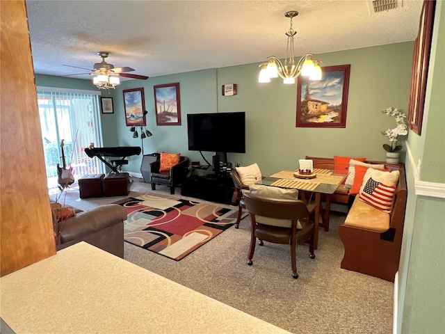 carpeted living room with a textured ceiling, ceiling fan with notable chandelier, and visible vents