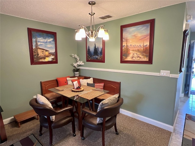 carpeted dining space featuring a chandelier, visible vents, a textured ceiling, and baseboards