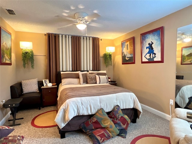 bedroom with a textured ceiling, ceiling fan, visible vents, baseboards, and carpet