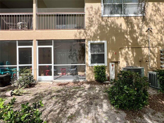 entrance to property with central AC and stucco siding