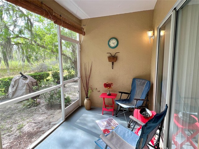 sunroom with a textured wall and concrete floors