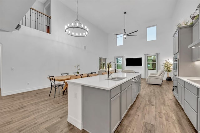 kitchen with light wood finished floors, open floor plan, a sink, and gray cabinetry