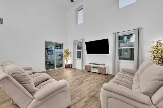 living area with a healthy amount of sunlight, visible vents, and wood finished floors