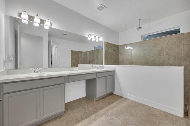 bathroom featuring a walk in shower, double vanity, a sink, and visible vents