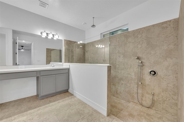 bathroom featuring visible vents, ceiling fan, vanity, and a walk in shower