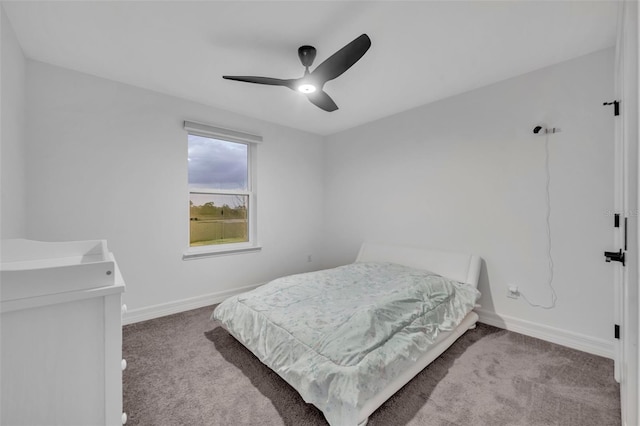 carpeted bedroom with ceiling fan and baseboards