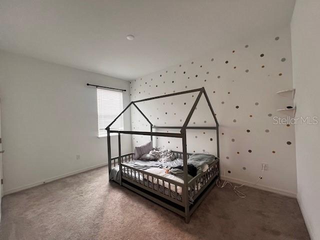 bedroom featuring baseboards, carpet floors, and wallpapered walls