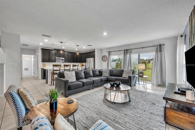 living room with light tile patterned flooring, visible vents, recessed lighting, and a textured ceiling