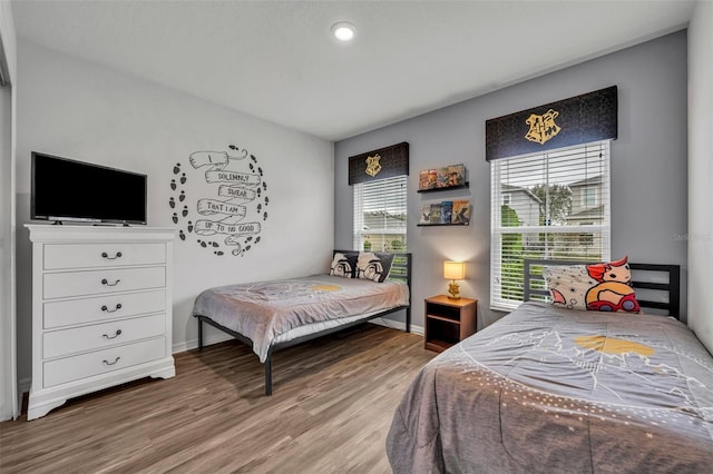 bedroom featuring baseboards and wood finished floors