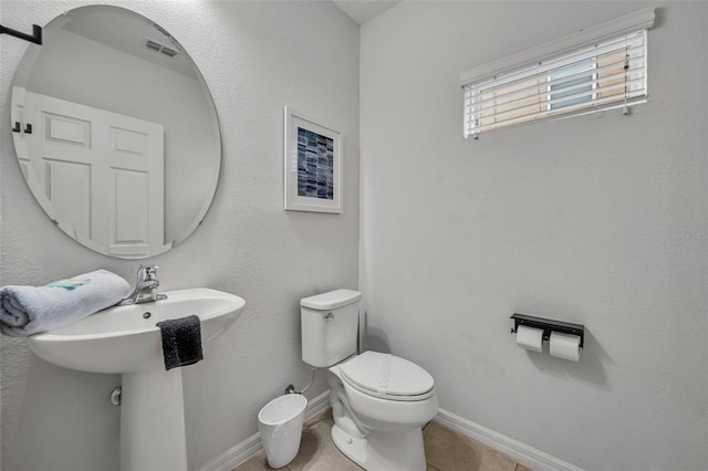 bathroom with visible vents, toilet, a sink, tile patterned flooring, and baseboards