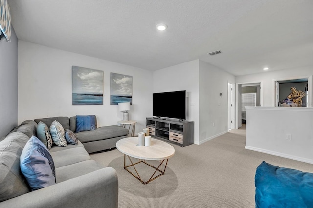 living area with recessed lighting, visible vents, light carpet, and baseboards