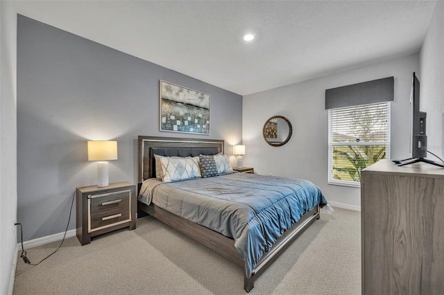 bedroom featuring baseboards and light colored carpet