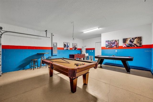 recreation room with electric panel, pool table, a textured ceiling, and concrete block wall