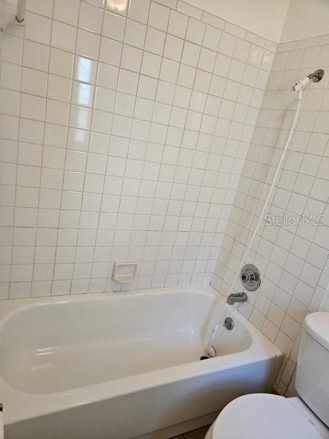 bathroom featuring shower / washtub combination and toilet