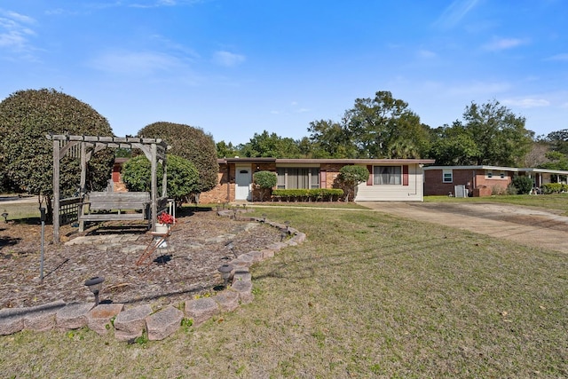 ranch-style home featuring driveway, a front lawn, brick siding, and a pergola