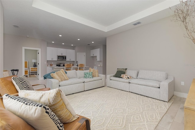 living area with baseboards, visible vents, and recessed lighting