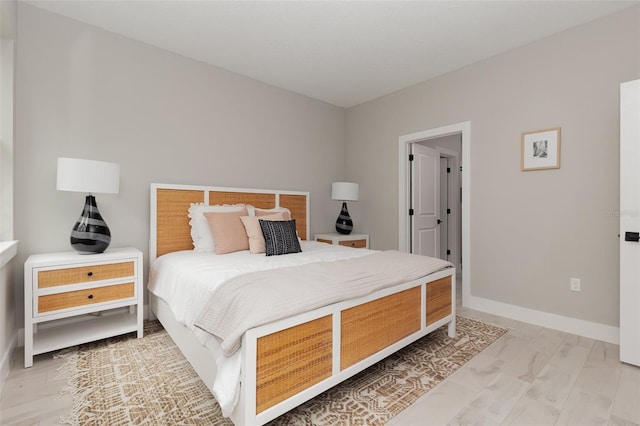 bedroom with light wood-type flooring and baseboards