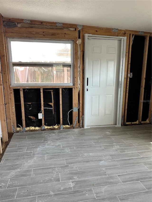 unfurnished room with wood tiled floor and a textured ceiling