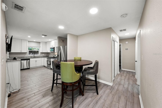 dining space featuring baseboards, recessed lighting, visible vents, and wood tiled floor