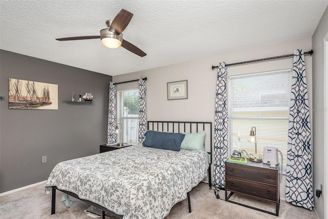 bedroom featuring a textured ceiling, carpet floors, a ceiling fan, and baseboards