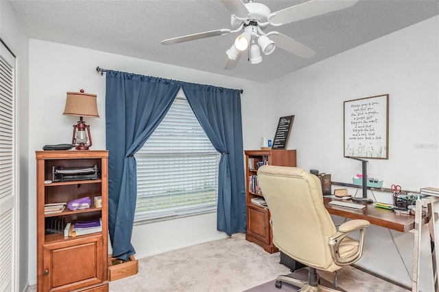 office area featuring a ceiling fan, light colored carpet, and a textured ceiling