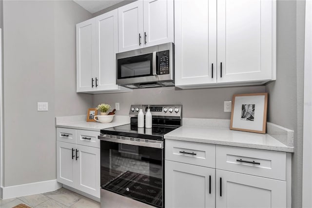 12639 SW 78th Pl, Dunnellon, FL 34432 - kitchen with appliances with stainless steel finishes, baseboards, white cabinets, light marble finish floors, and light stone counters