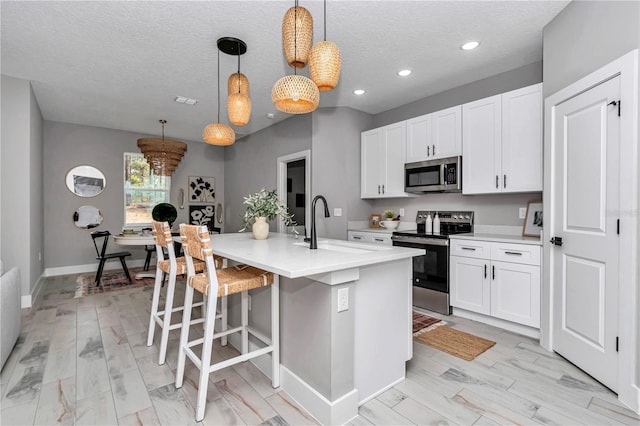 12639 SW 78th Pl, Dunnellon, FL 34432 - kitchen with appliances with stainless steel finishes, a textured ceiling, light countertops, white cabinets, and recessed lighting