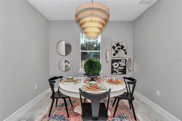 12639 SW 78th Pl, Dunnellon, FL 34432 - dining room with light wood-style floors, baseboards, a chandelier, and a textured ceiling