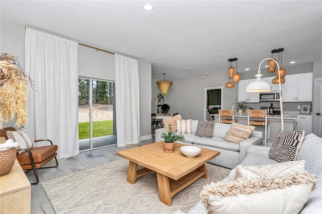 12639 SW 78th Pl, Dunnellon, FL 34432 - living room featuring a textured ceiling, light wood finished floors, recessed lighting, and baseboards