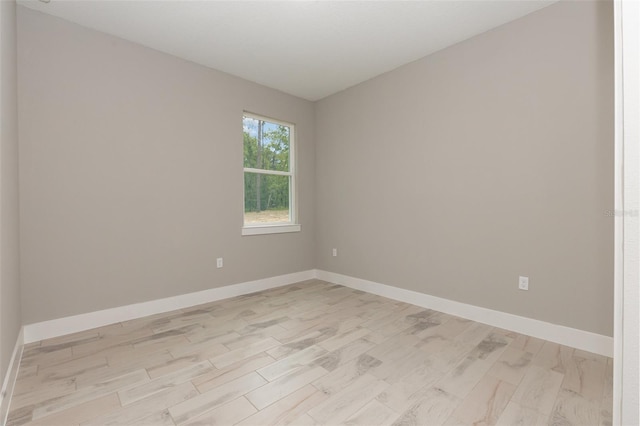 spare room featuring light wood-style flooring and baseboards