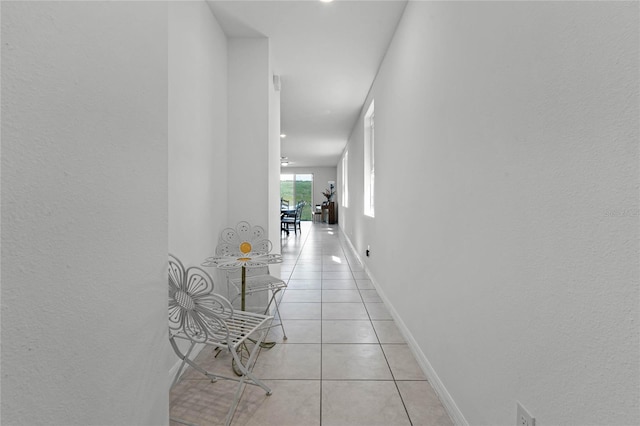 hallway featuring light tile patterned floors and baseboards