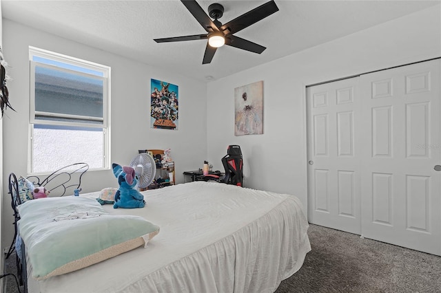 carpeted bedroom with a textured ceiling, a closet, and a ceiling fan