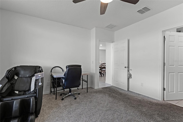 carpeted home office with a ceiling fan, visible vents, a textured ceiling, and baseboards