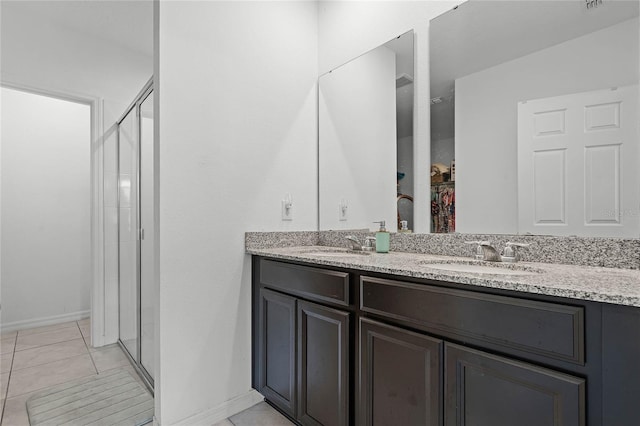 bathroom with double vanity, tile patterned flooring, a sink, and a shower stall