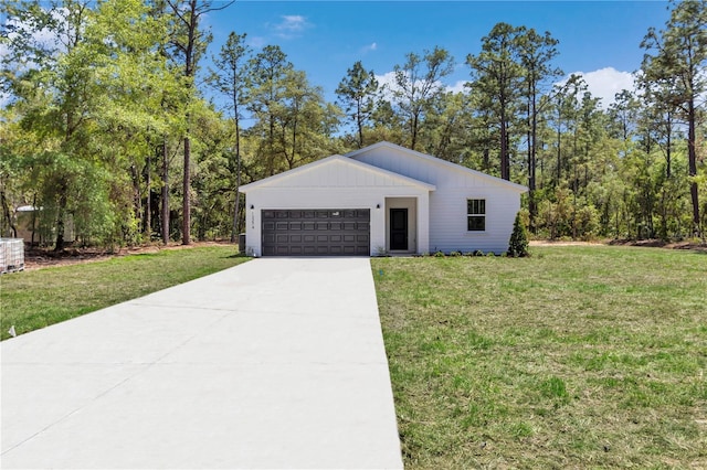 view of front of property featuring an attached garage, concrete driveway, and a front yard