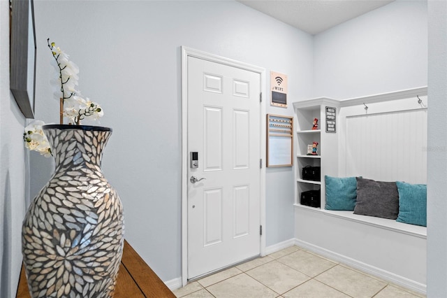 interior space featuring light tile patterned floors and baseboards