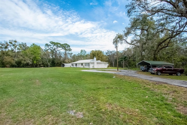 view of yard with a carport and driveway